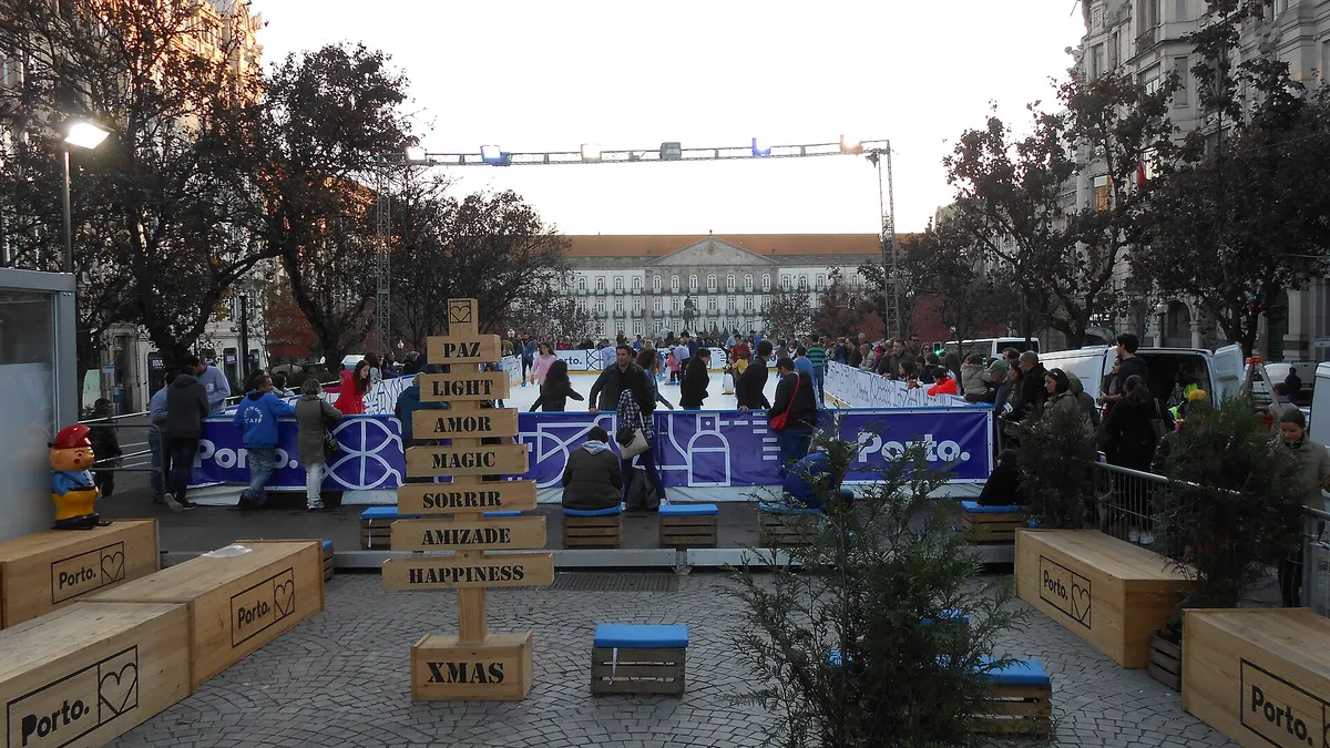 Seasonal ice skating on a city avenue, holiday decorations and crowds around the rink