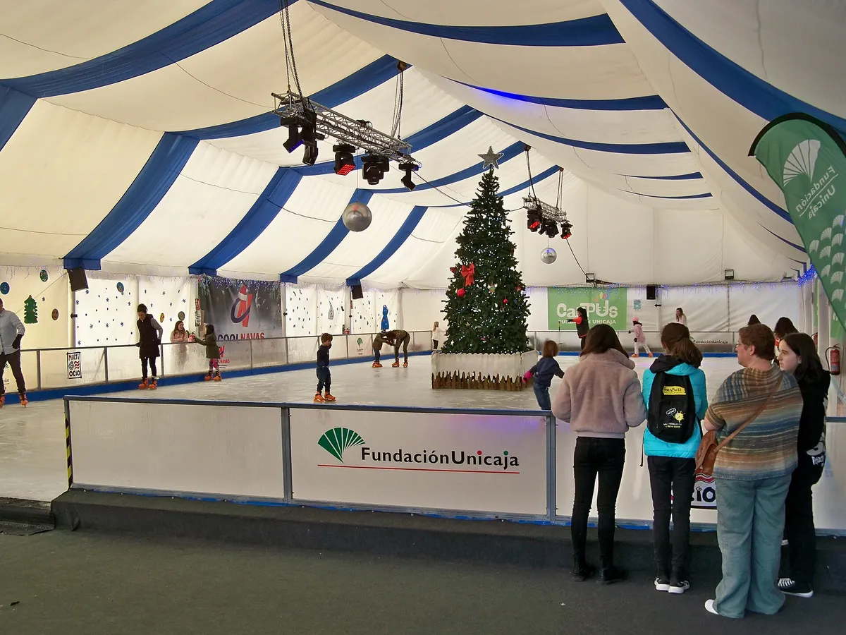 Skaters on an outdoor rink on a sunny avenue, palm trees and city life around