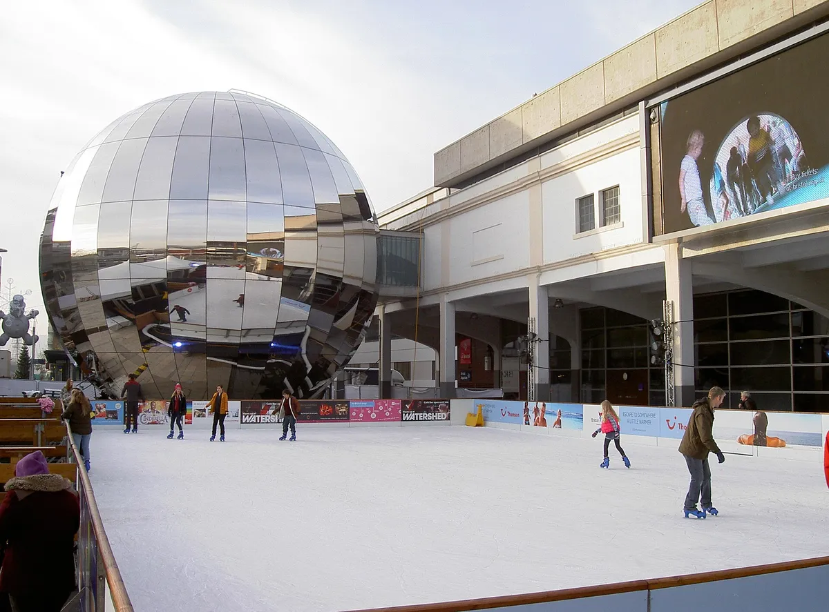 Skaters on a small outdoor rink, families enjoying a winter afternoon
